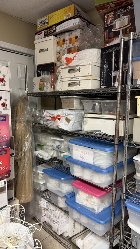 Recipientes transparentes, cajas y vajilla en estantes